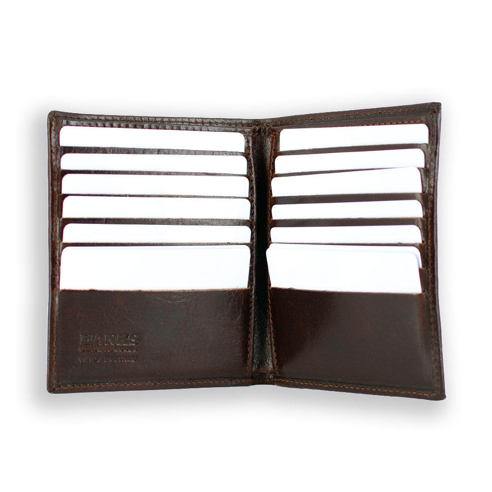 The Iseo Italian Hipster Bifold from Hanks Belts is an open brown leather wallet with several white cards visible in its 14 credit card slots, arranged in two rows on either side. The wallet's simple and organized design is prominently displayed on a plain white background.
