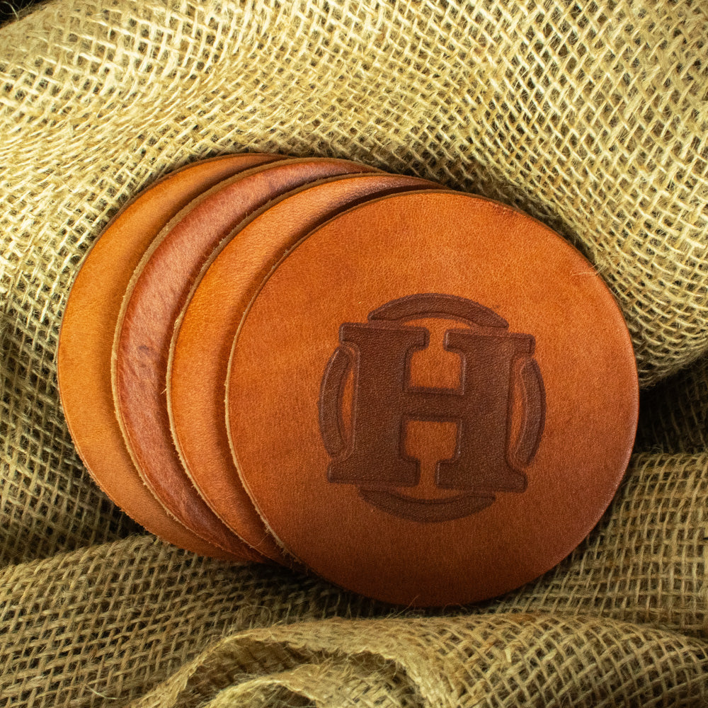 Set of 4 round leather coasters laying on burlap in retro tan