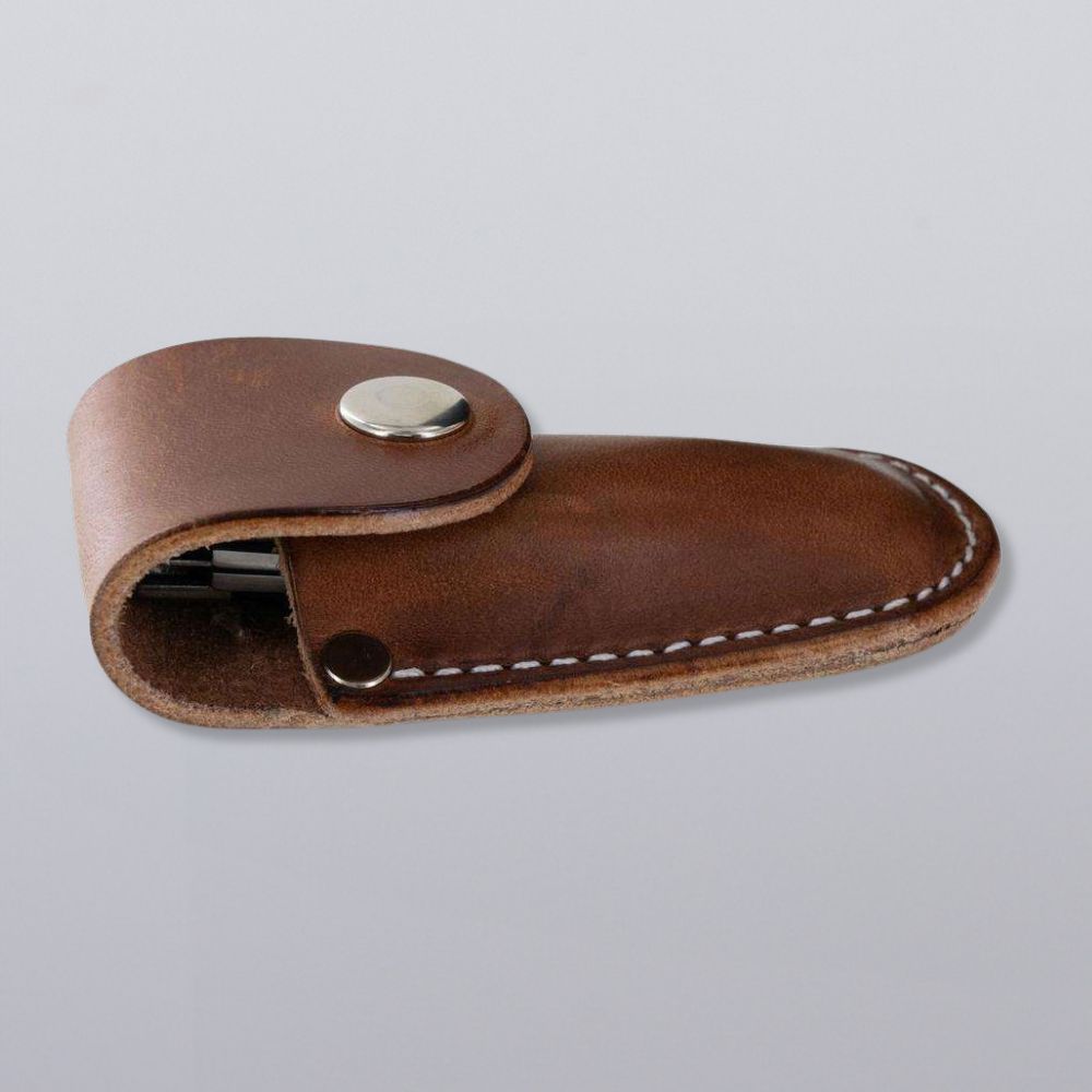 The Canyon Utility Sheath and Mag Case by Hanks Belts features brown bridle leather, white stitching, and a metal snap, shown closed on a light gray background. Made in the USA for durability and lasting quality.