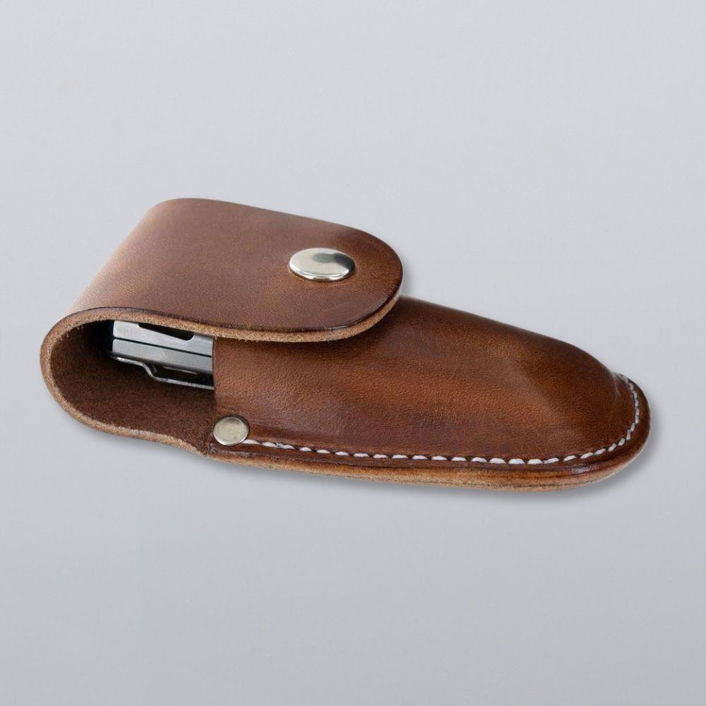 The Canyon Utility Sheath and Mag Case by Hanks Belts is crafted in the USA from brown bridle leather with white stitching and a metal snap, partially open to reveal contents, photographed on a plain gray background.