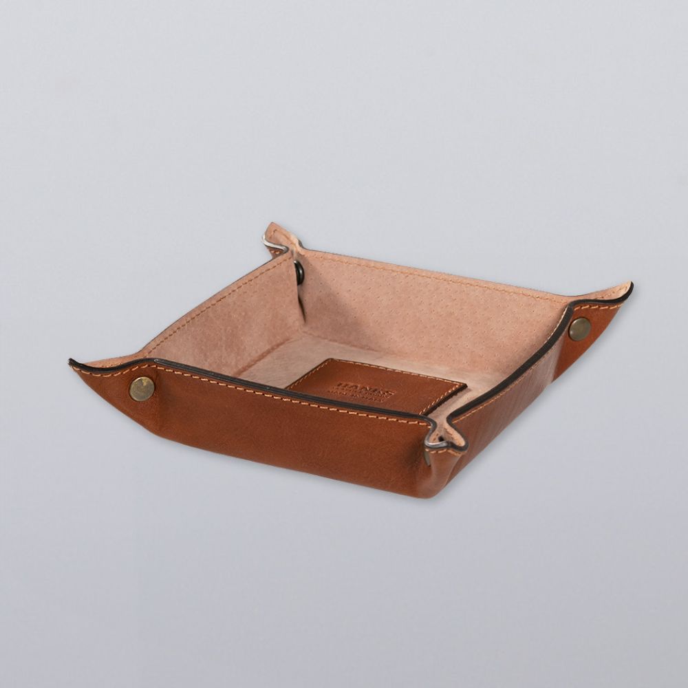 The Hanks Belts Italian Compact Valet Tray, crafted from Italian leather with exposed stitching and snap corners, is shown on a light gray surface.