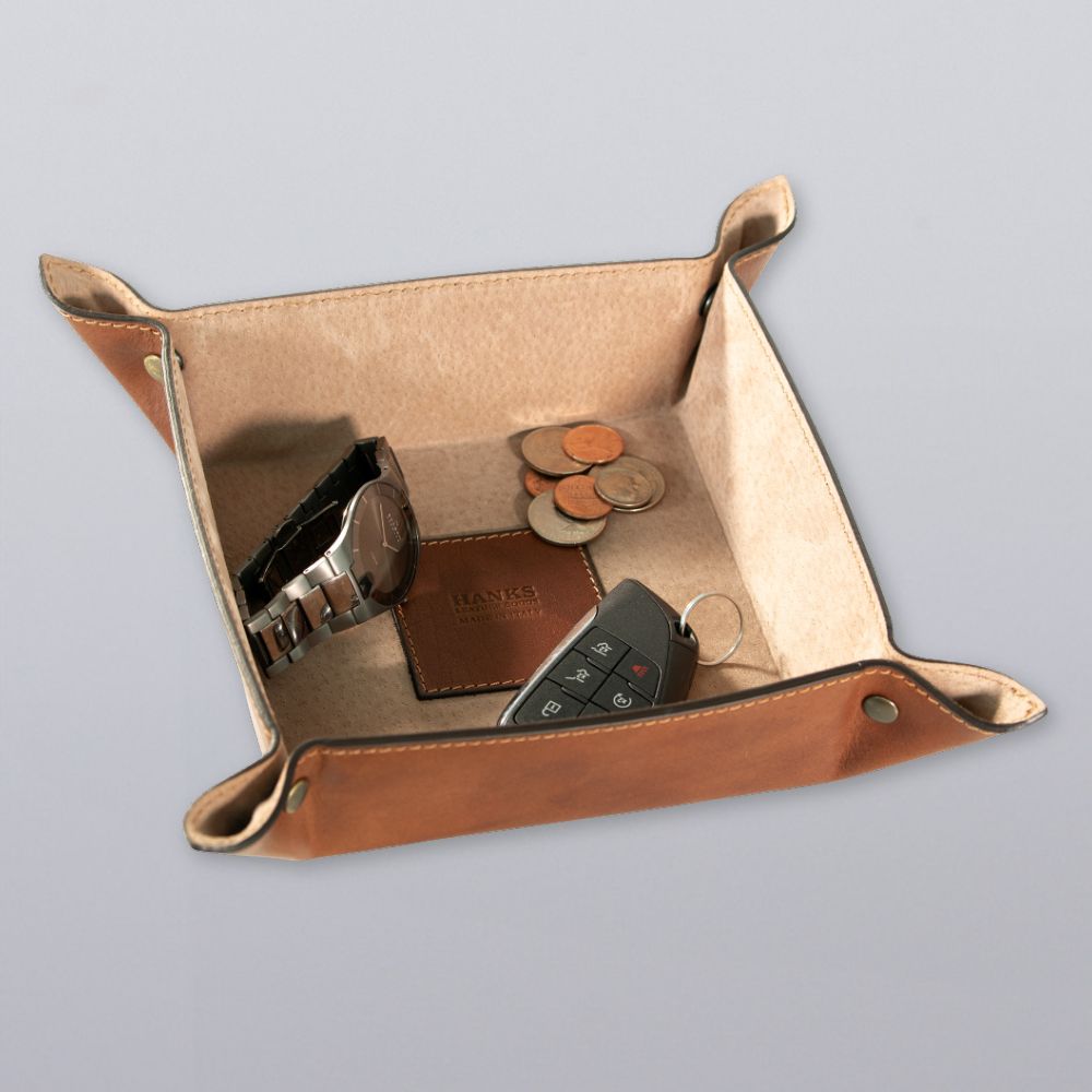 The Hanks Belts Italian Large Valet Tray holds a wristwatch, car key fob, and coins on a light gray surface.