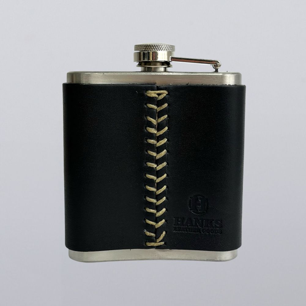 The Leather Covered Flask by Hanks Belts features black leather with tan stitching and an embossed logo—an elegant, USA-made stainless steel flask perfect for any occasion.