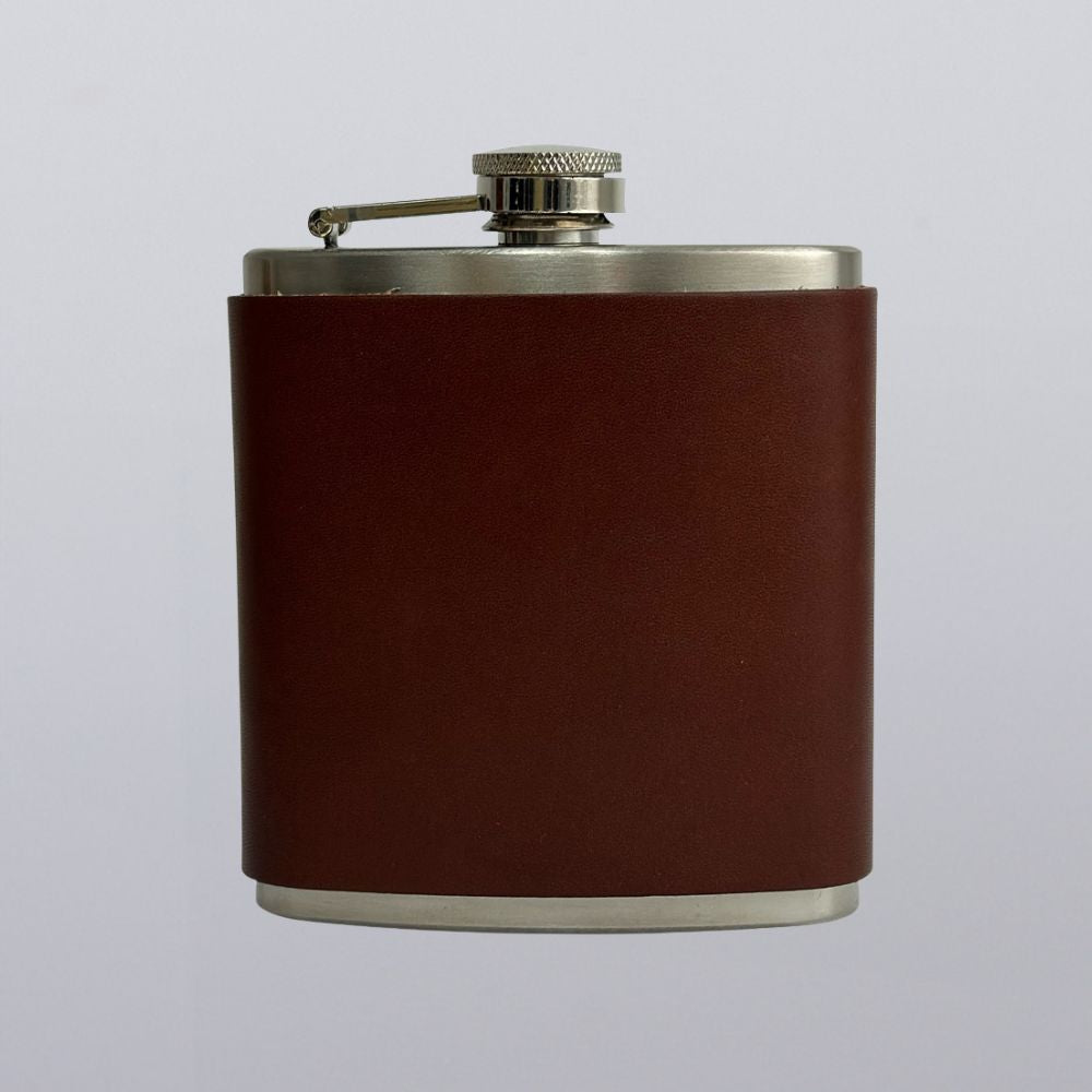 The Hanks Belts Leather Covered Flask features a brown leather wrap over stainless steel, made in the USA and shown against a plain light gray backdrop.