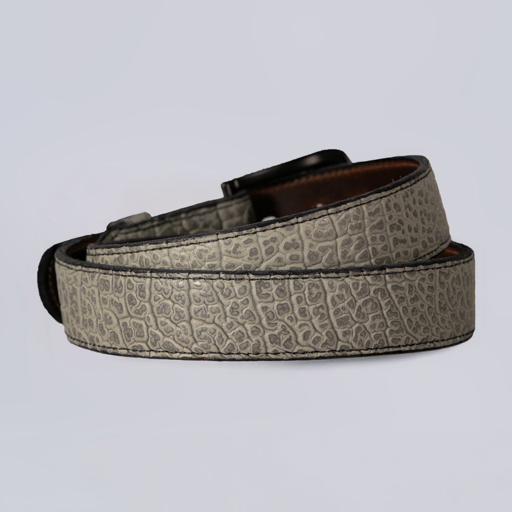 The Bison Bellow by Hanks Belts is a shrunken bison leather belt with a textured gray crocodile skin pattern and a dark buckle, shown rolled up against a light gray background.