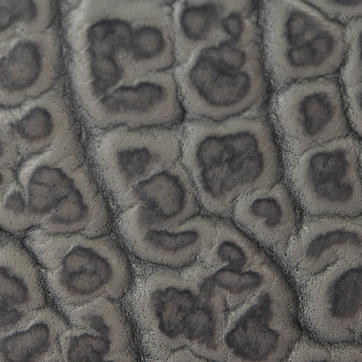 Close-up of Bison Bellow by Hanks Belts—textured gray surface with irregular, raised ovals and dark outlines, evoking the distinctive full-grain bison leather found on a premium limited-edition belt.