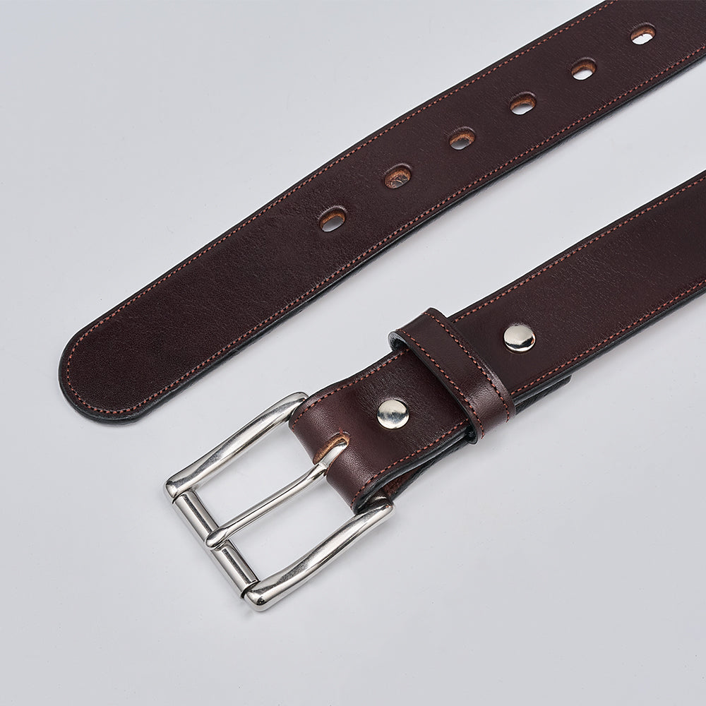 The Canyon by Hanks Belts is a handcrafted belt made from rich brown English bridle leather, featuring a silver metal buckle, multiple holes, and detailed edge stitching. It’s shown laid flat on a light gray surface.