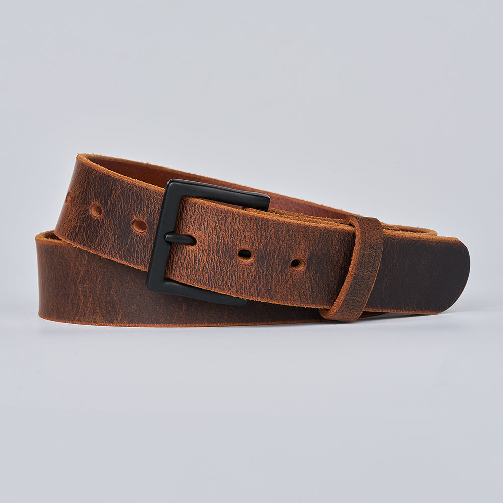 The Crazy Horse by Hanks Belts—a brown Water Buffalo leather belt with a matte black rectangular buckle—coiled in a simple loop on a light gray background.