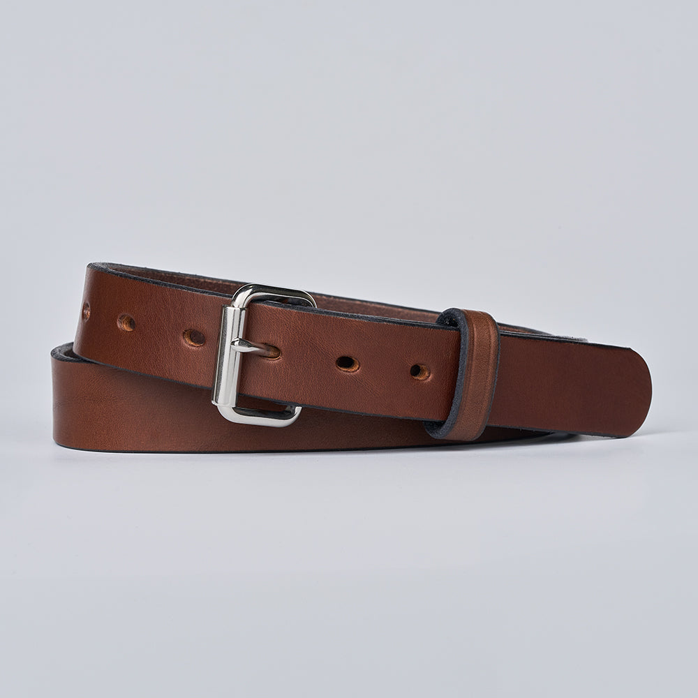 The Deputy by Hanks Belts—a brown narrow leather belt with a silver buckle—coiled neatly on a plain light gray background.