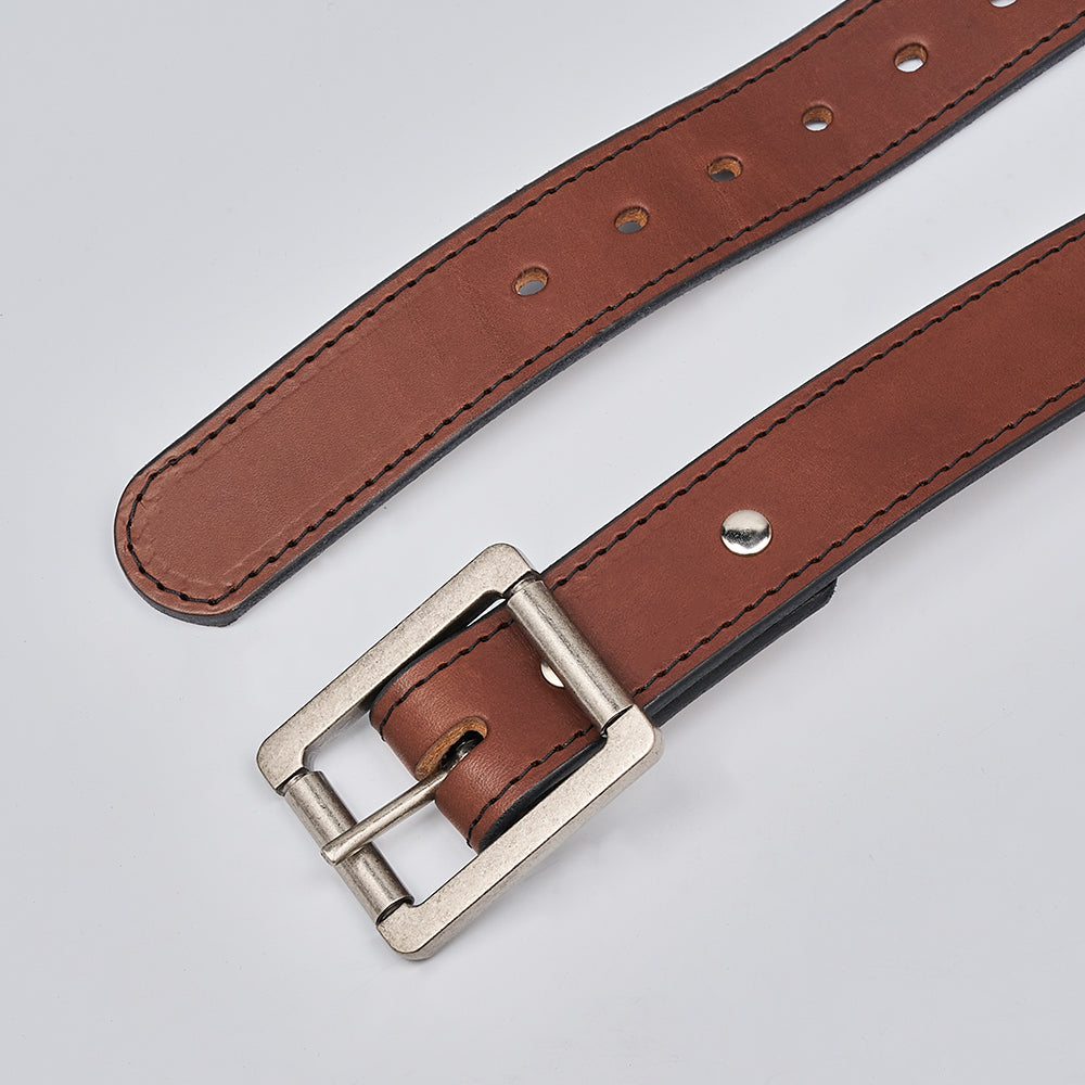 A close-up of The Double Roller by Hanks Belts, a USA-made work belt in brown full-grain leather with a silver rectangular buckle and multiple adjustment holes, displayed on a plain light gray background.