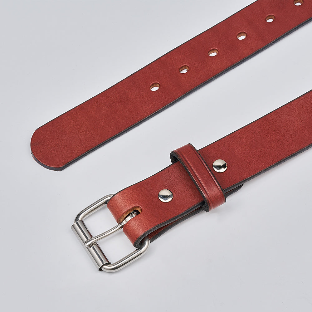 The Gunner by Hanks Belts is a brown leather work belt featuring a silver buckle, multiple adjustment holes, and metal rivets, shown on a light gray background.