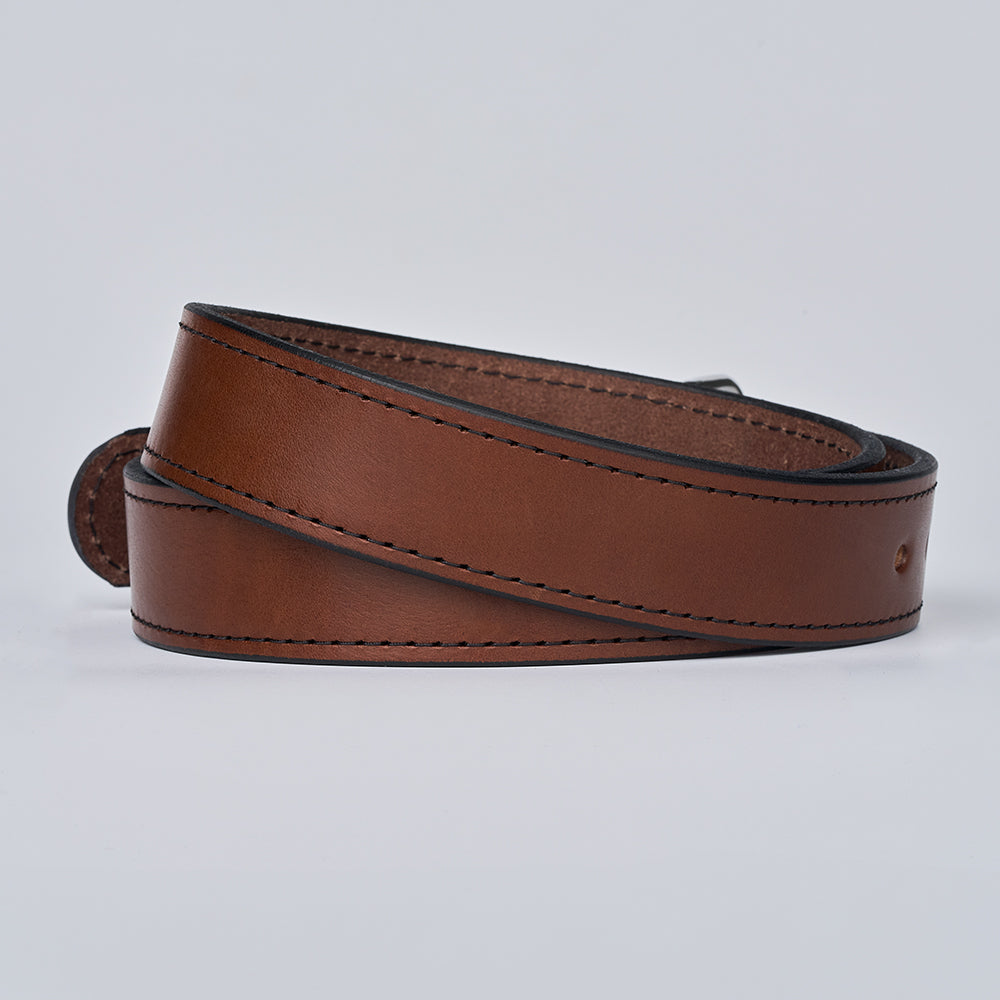 The Gunner Stitched by Hanks Belts: a coiled brown full-grain leather belt with black edges and visible stitching, displayed on a plain light background.