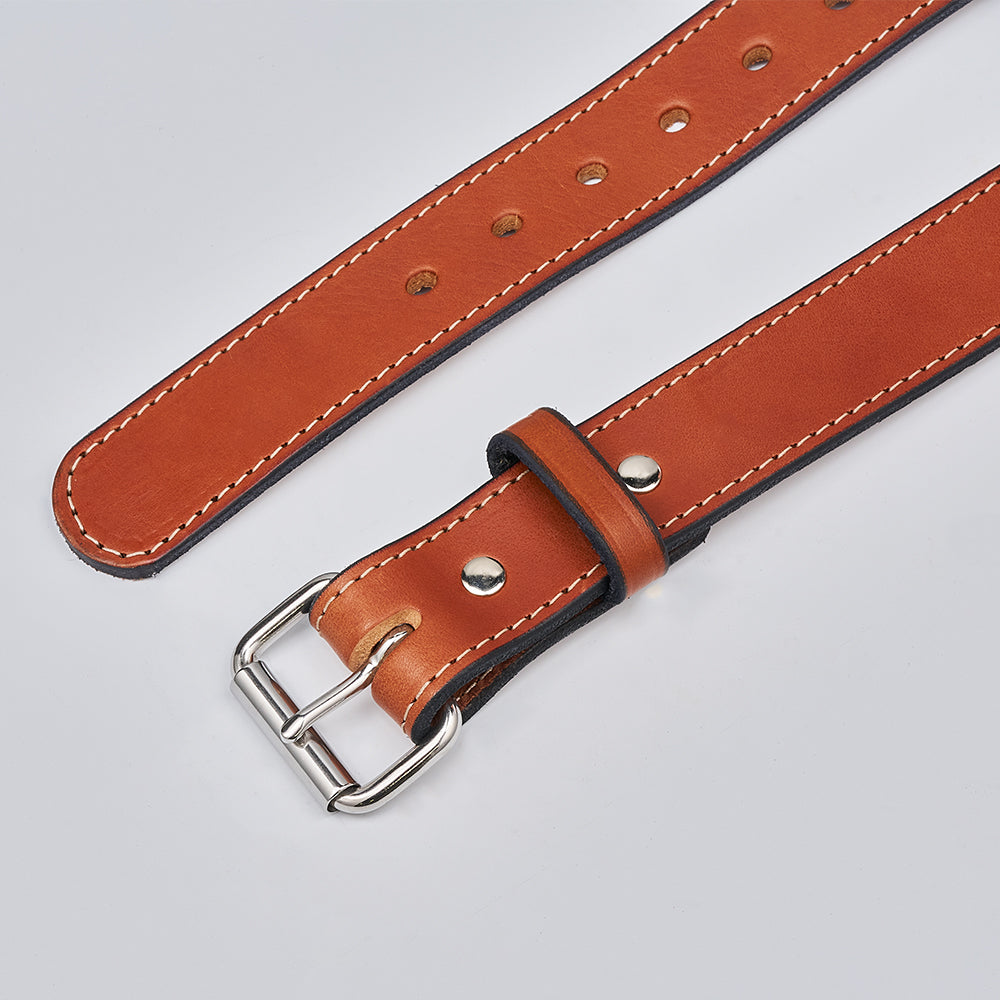The Gunner Stitched by Hanks Belts is a brown full-grain leather gun belt featuring white stitching, a silver buckle, and metal rivets, shown laid flat on a light gray surface.