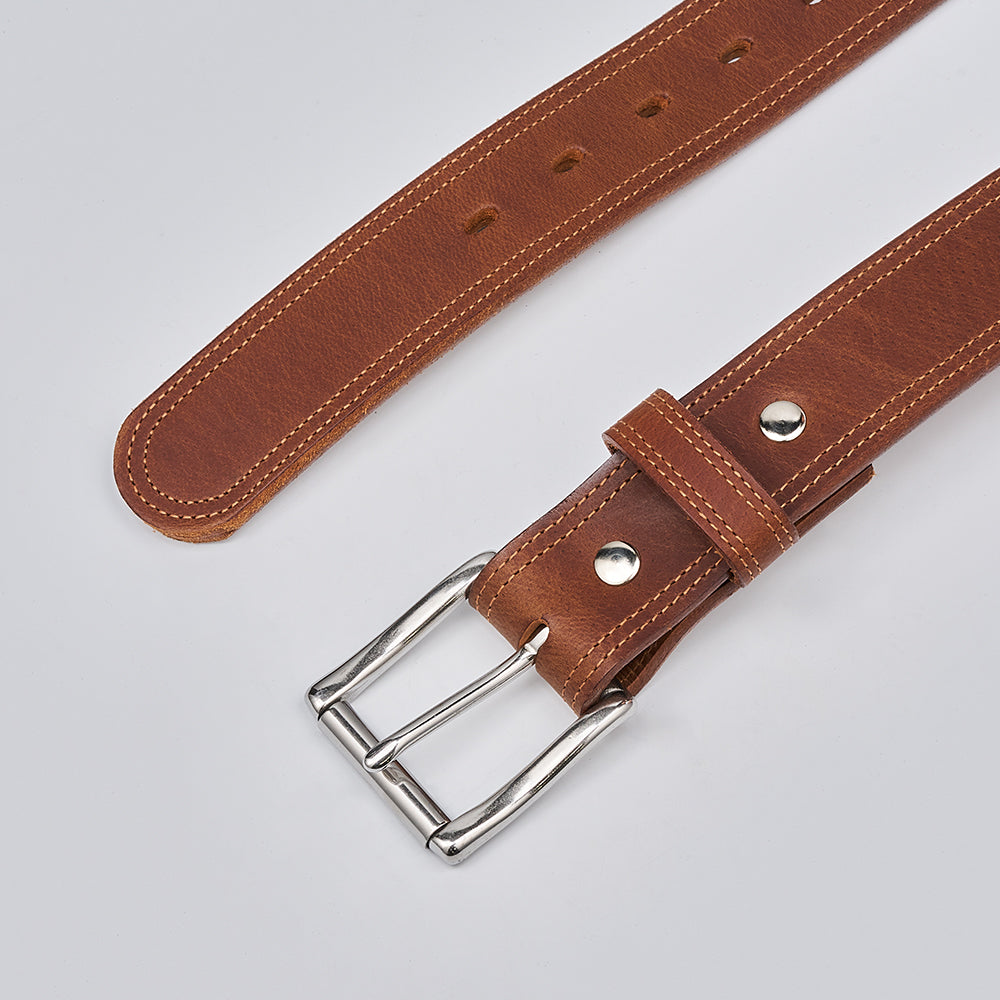 Brown leather belt with silver buckle on a light gray background