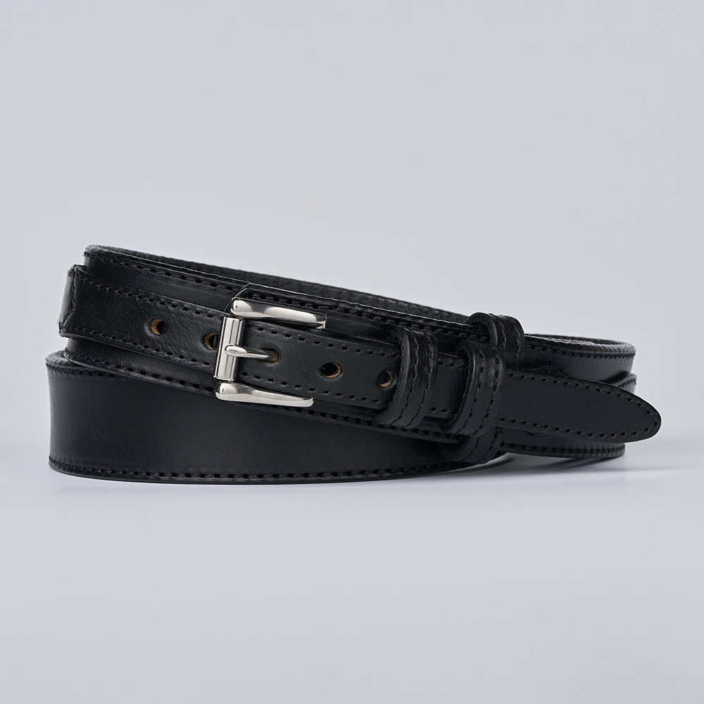 The Ranger by Hanks Belts is a coiled black full-grain leather belt with a silver buckle, visible stitching, and evenly spaced holes. It’s displayed on a plain light gray background and showcases classic ranger belt styling.