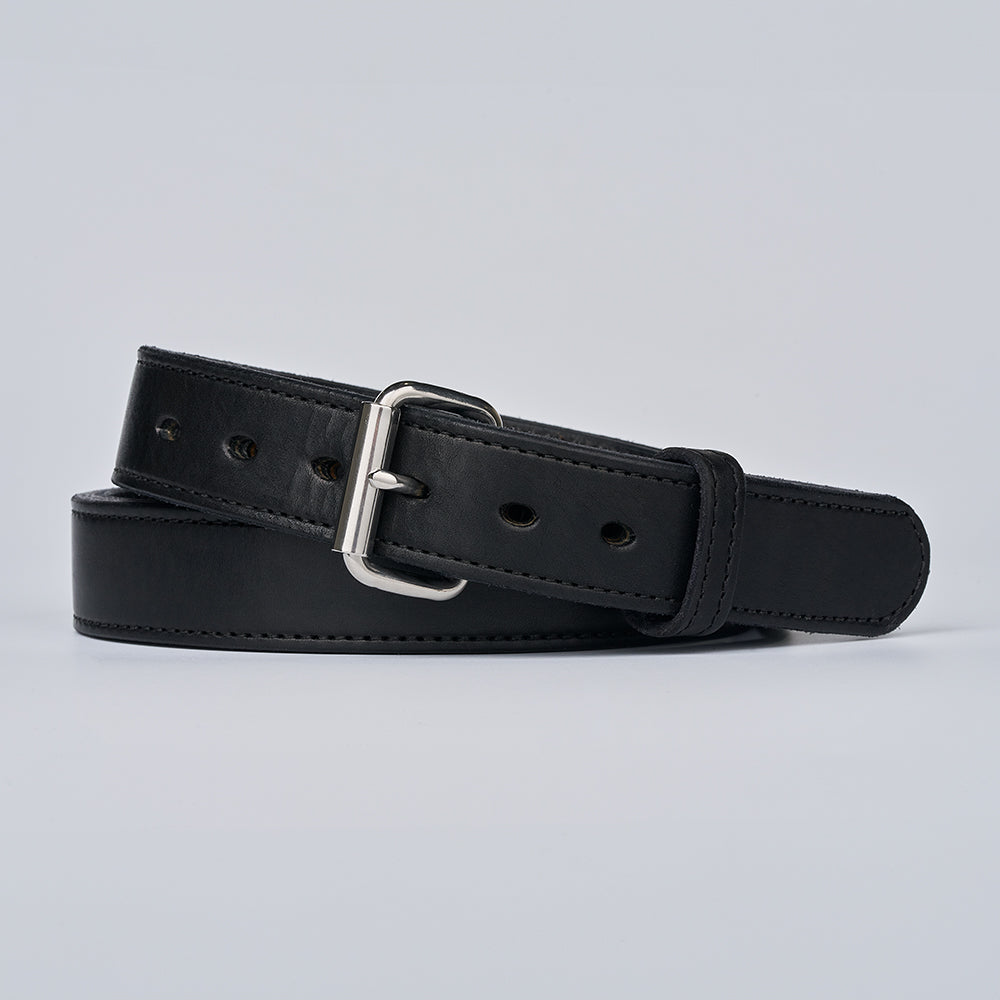 The Steel Core - 1.5" by Hanks Belts, a black leather gun belt with a silver buckle, is shown coiled flat on a plain light gray background.