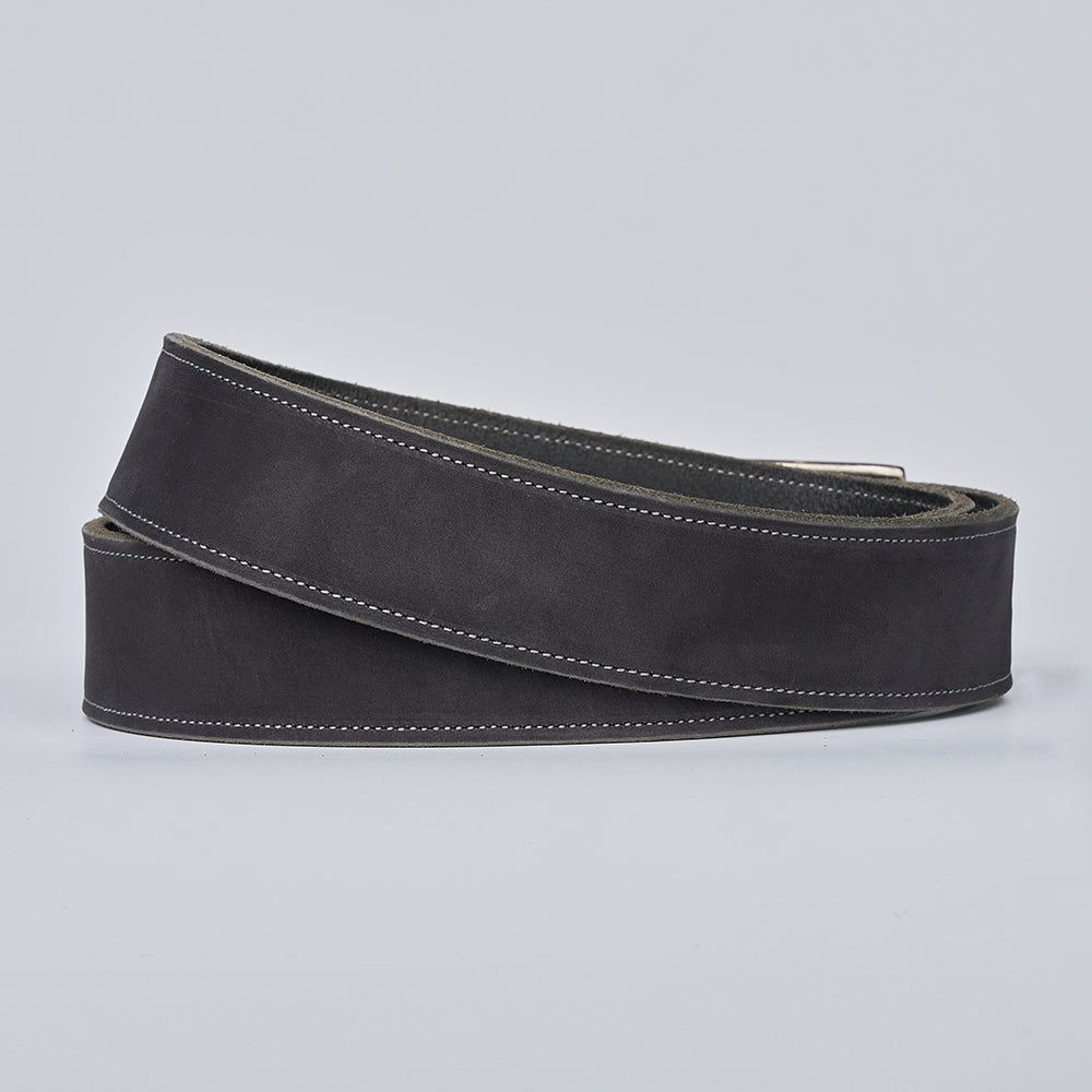 The Suede - 1.5" belt by Hanks Belts, in black nubuck leather with white stitching, is shown coiled in a loose spiral on a plain light gray background.