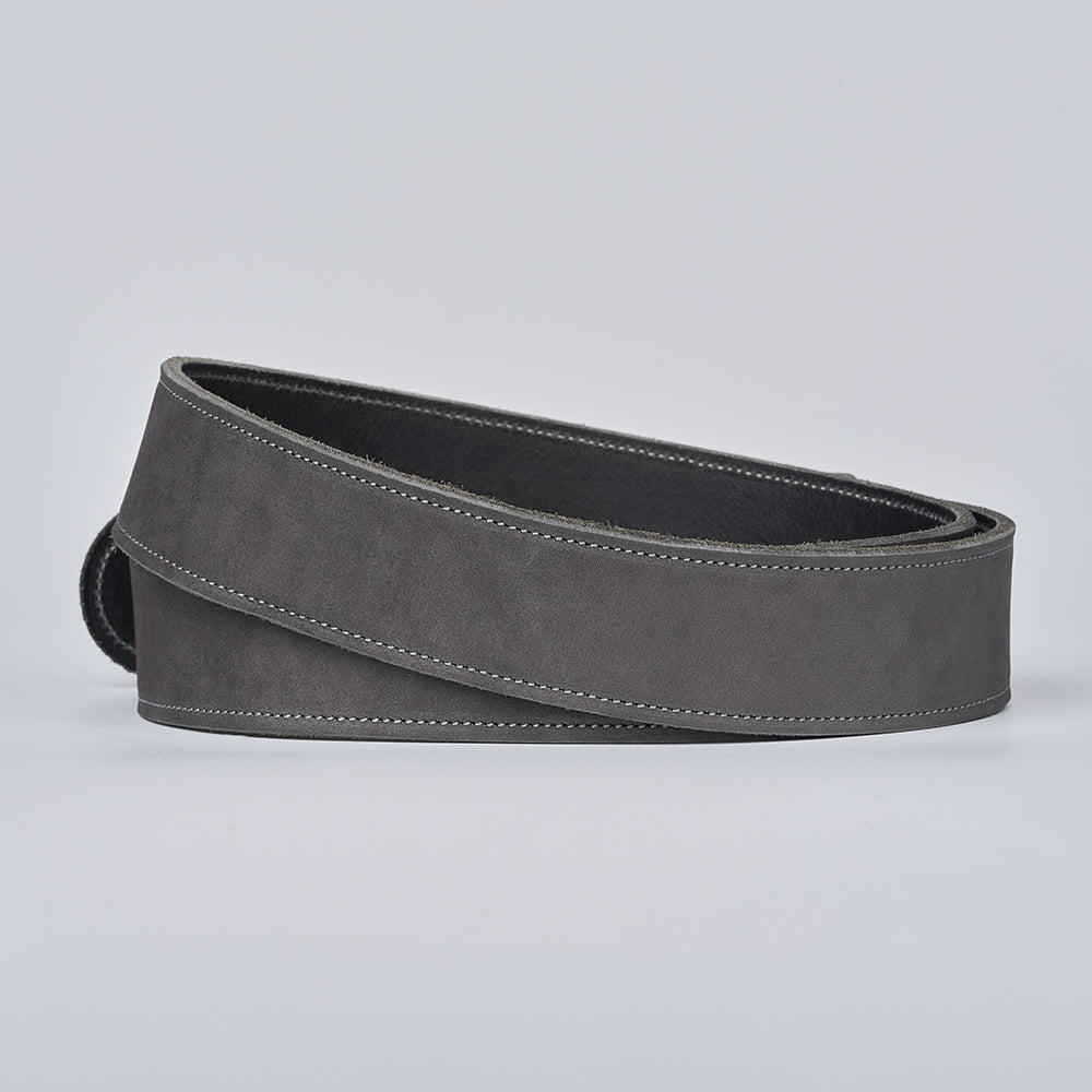 The Suede - 1.5" by Hanks Belts: a rolled-up grey Nubuck leather suede belt with white stitching, shown on a plain light grey background.