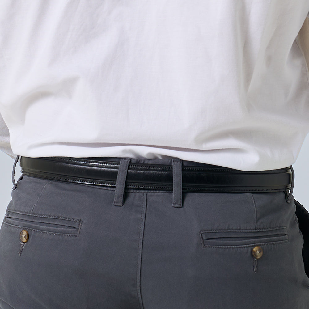 A person wearing gray pants with buttoned back pockets, a tucked-in white shirt, and Hanks Belts' The Esquire Raised premium leather belt, shown from the waist down and viewed from the back.
