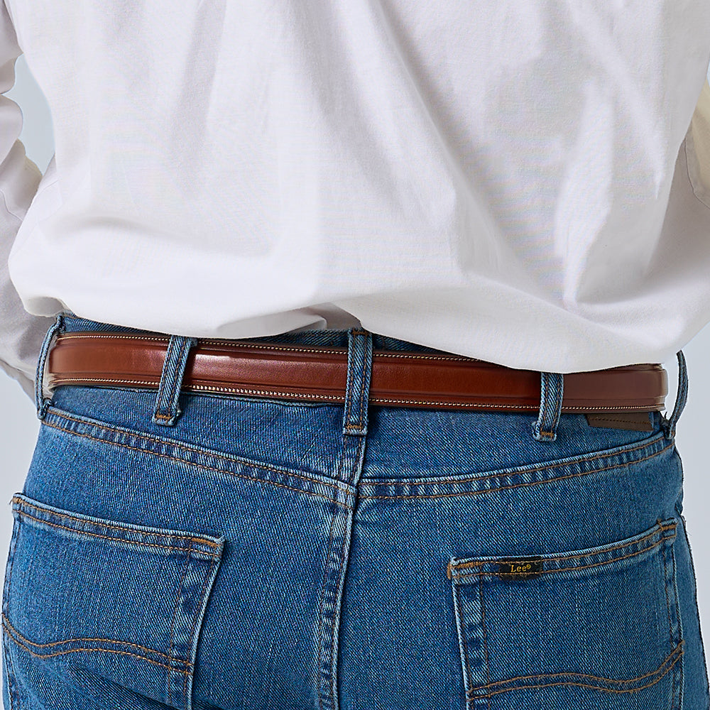A person wearing a white shirt tucked into blue jeans with The Esquire Raised premium leather belt by Hanks Belts, shown from the back.