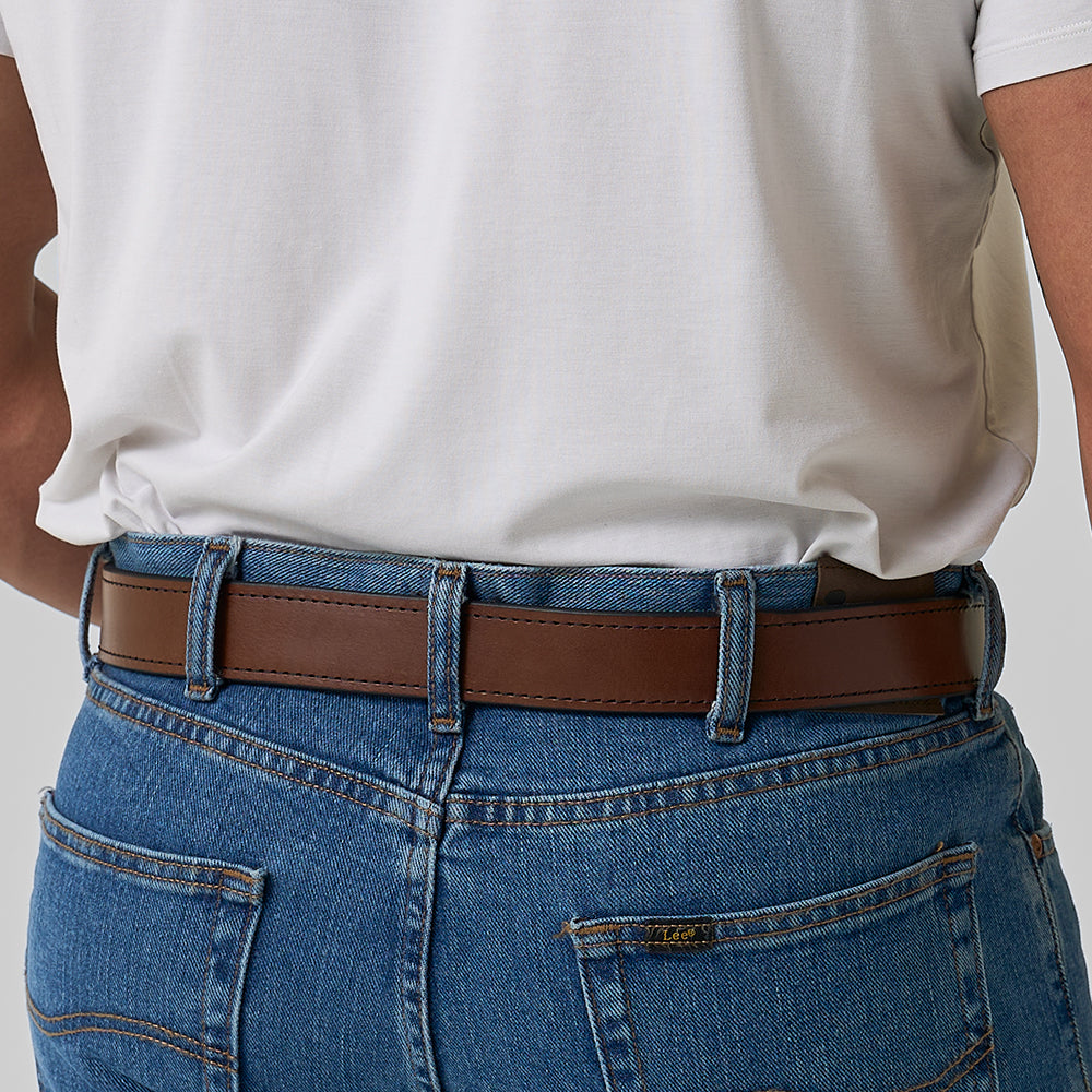 A person wearing blue jeans and a white t-shirt, shown from the back, with The Gunner Stitched full-grain leather CCW belt by Hanks Belts threaded through the belt loops.