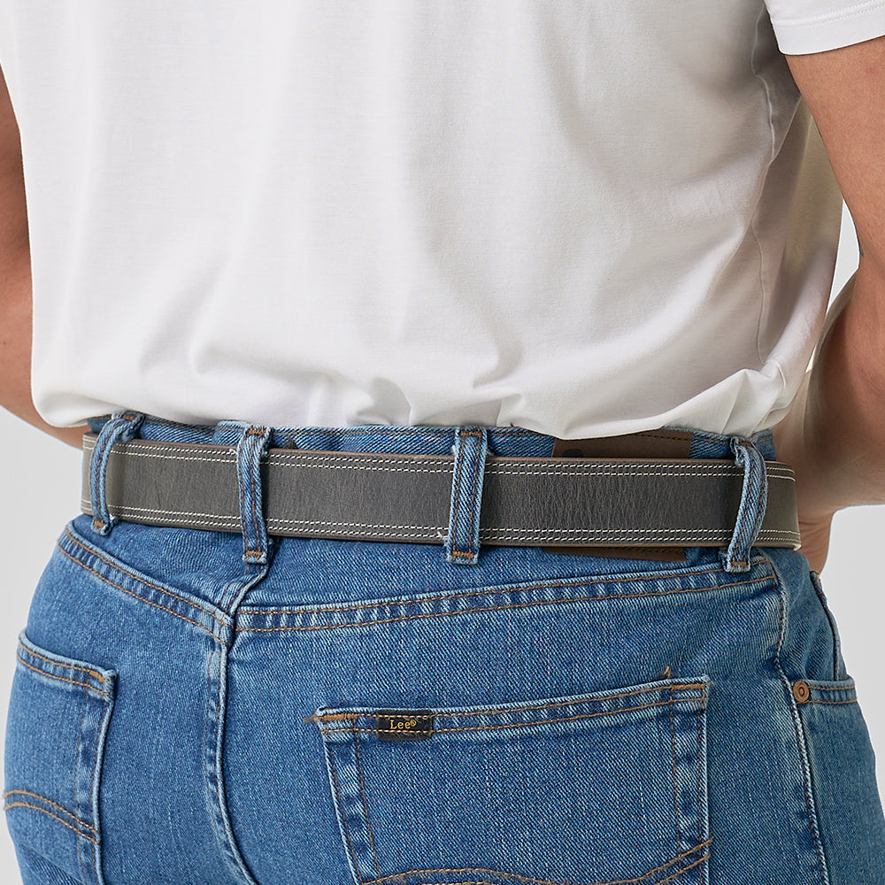 Person wearing blue jeans and a white shirt with a gray belt.