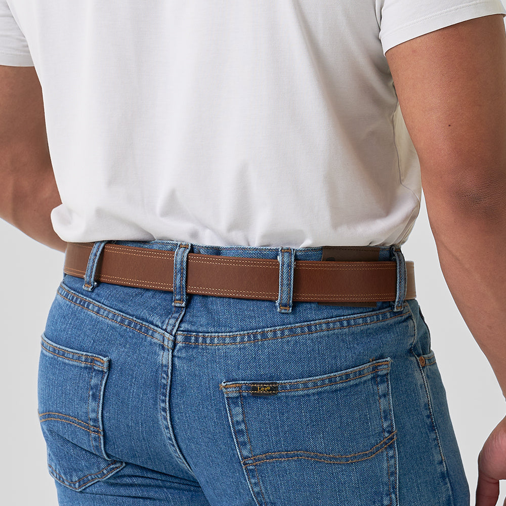 Person wearing blue jeans and a white shirt with a brown belt.