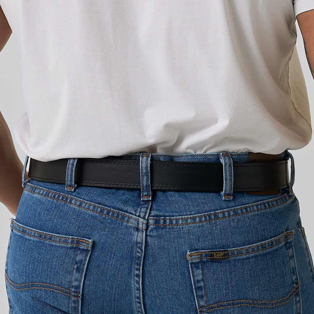 A person wearing a white t-shirt tucked into blue jeans with visible pockets and belt loops, shown from the back, modeling Hanks Belts' The Reversible CCW belt.
