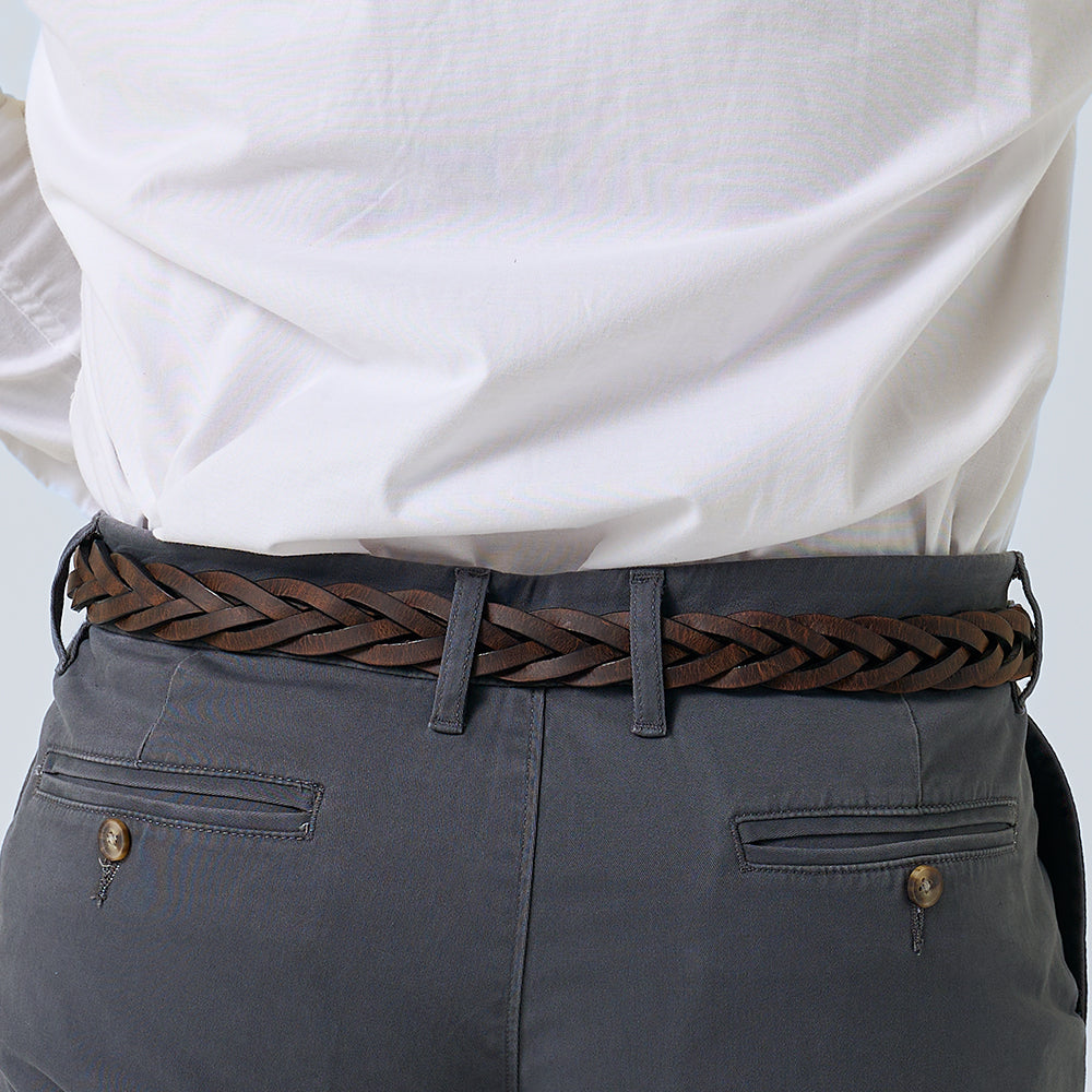 A person wearing a white shirt tucked into gray pants with buttoned back pockets and a Hanks Belts Rockford Braided Bison dark brown leather belt made in the USA.