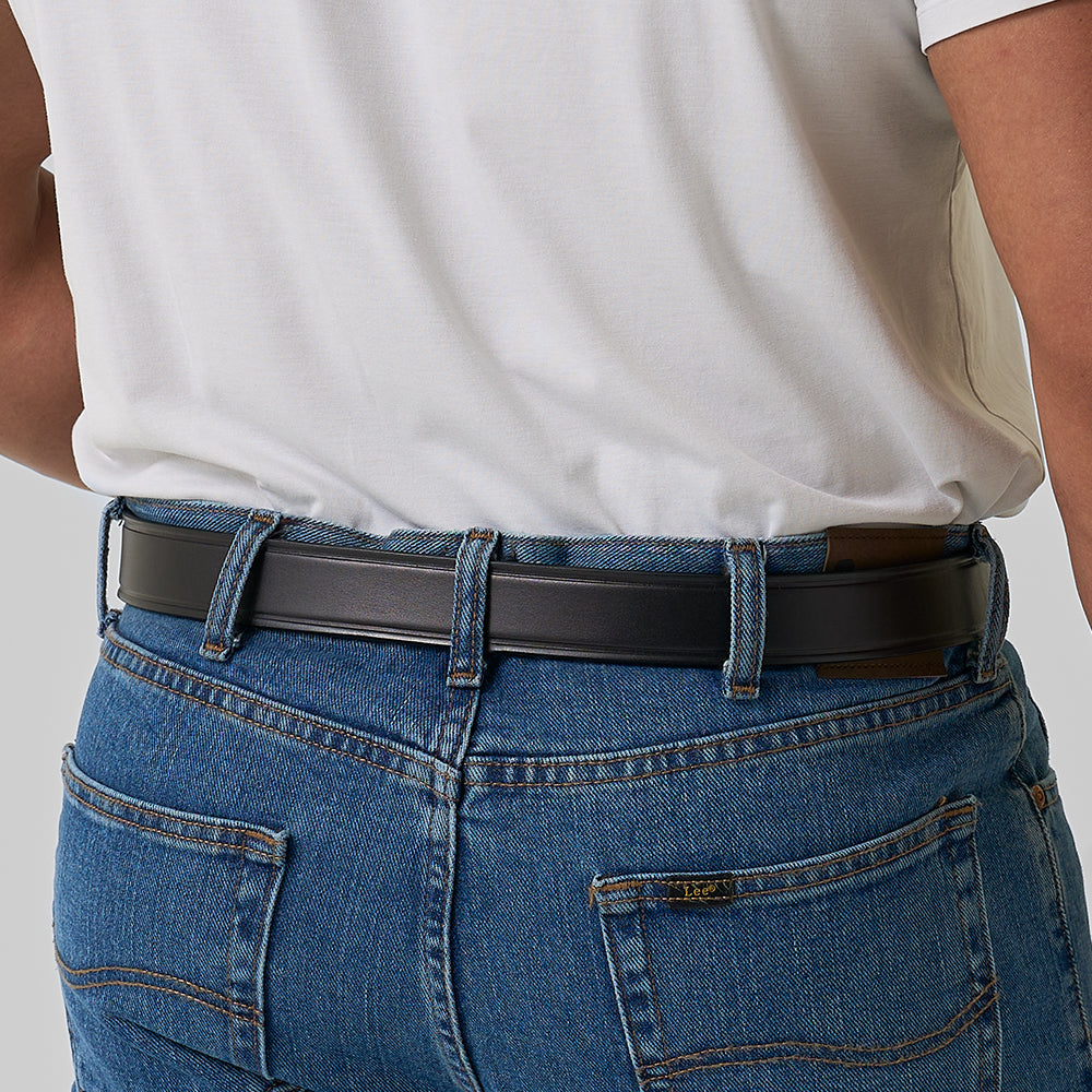 A person wearing a white shirt tucked into blue jeans, shown from the back, features The Scratchless Mechanics belt by Hanks Belts.