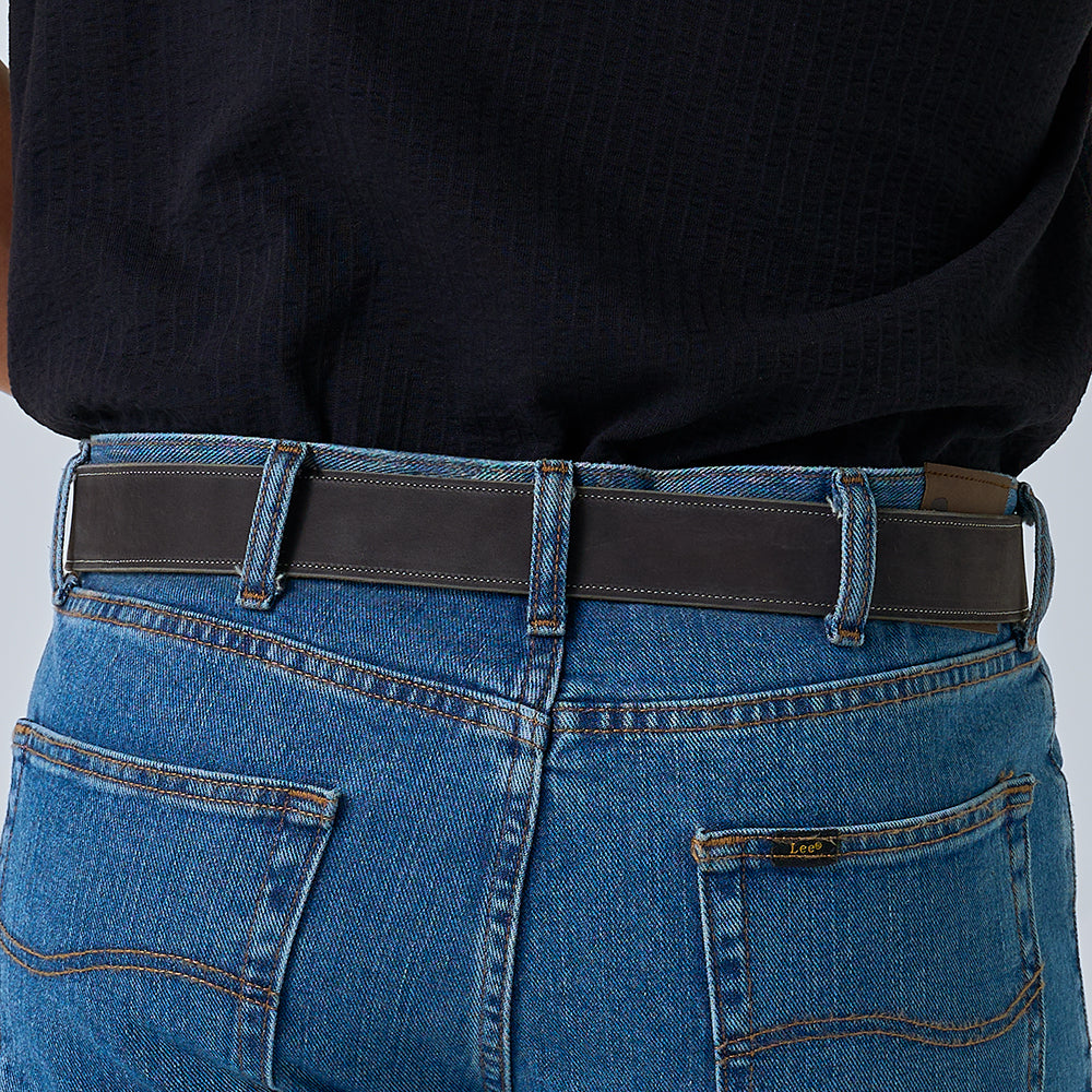 A person wearing blue Lee jeans and a black shirt, shown from the back, has The Suede - 1.5" belt by Hanks Belts (USA-made nubuck leather) threaded through the belt loops.