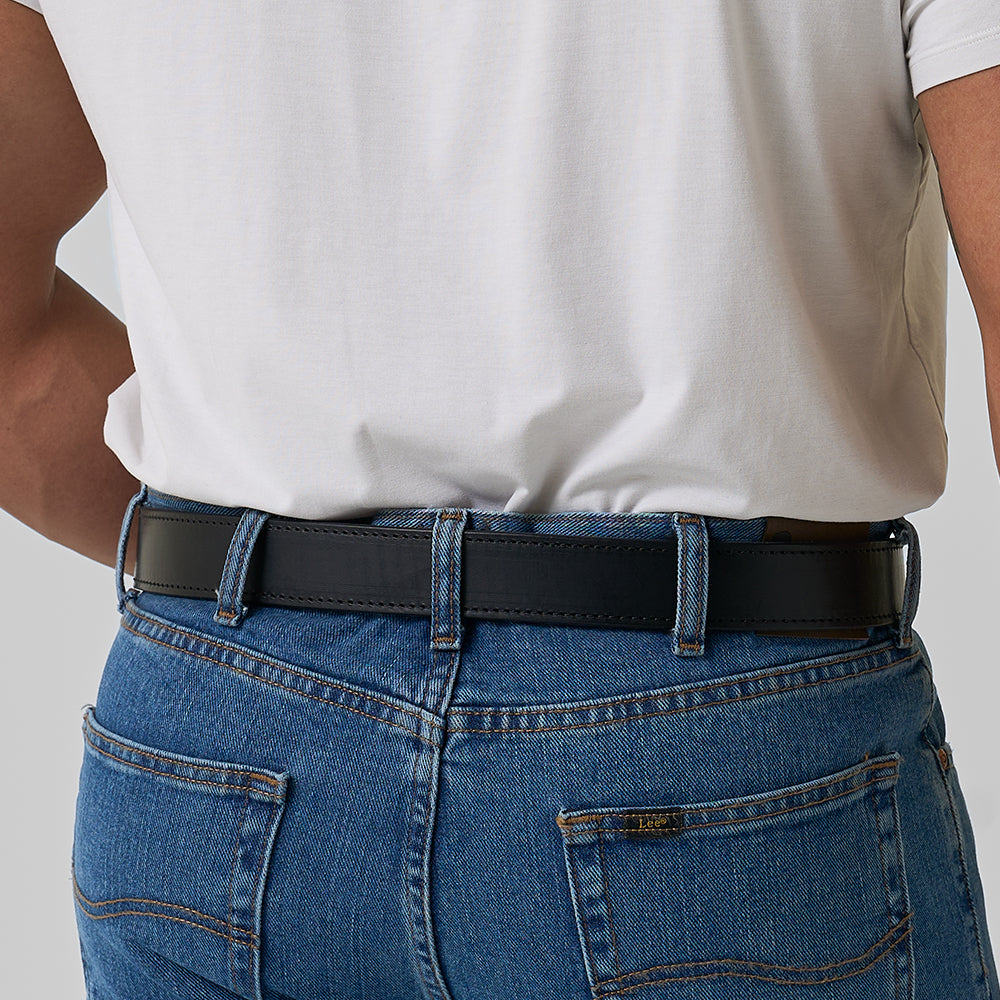 A person is shown from the back, focusing on the waist and lower back, wearing a white T-shirt, blue jeans, and Hanks Belts' The Xtreme - 1.5" black leather gun belt.