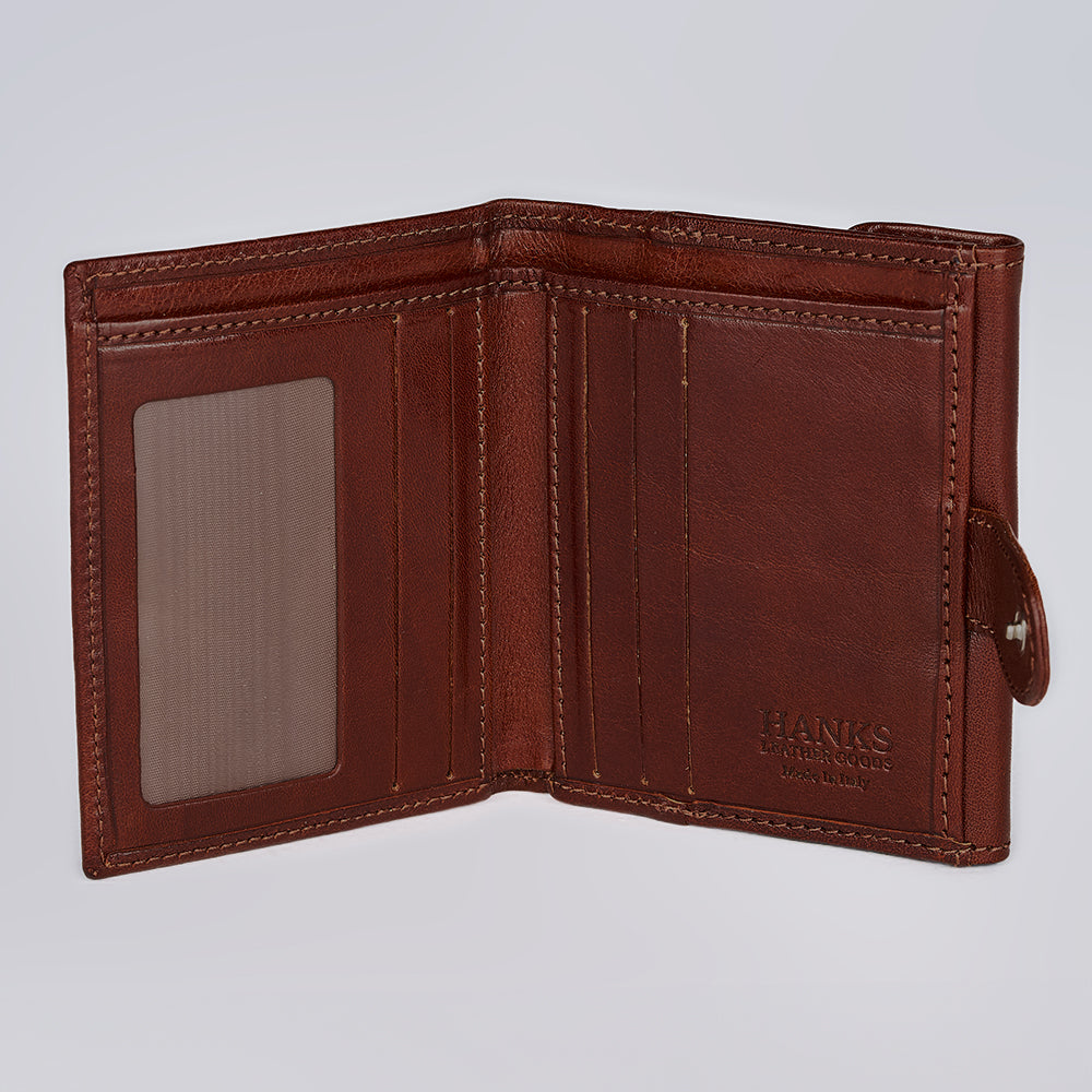 An open Adelina Mini Bifold by Hanks Belts, crafted in brown Italian leather, displays multiple card slots, a transparent ID window, and embossed "HANKS BELTS" branding against a plain light grey background.