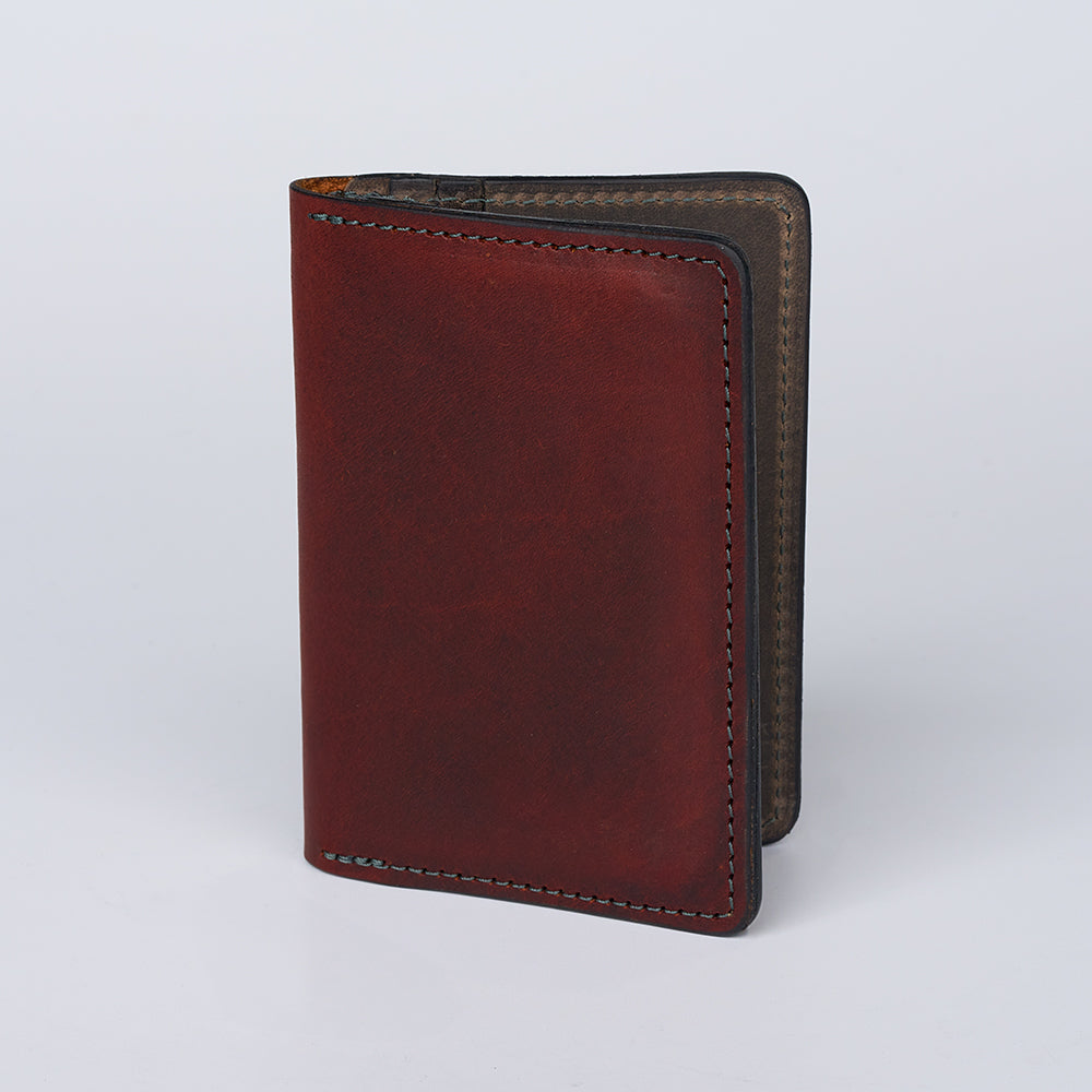 The Diablo Slimline Card Holder by Hanks Belts stands upright, partially open to reveal stitched edges and its interior against a plain light background. This slim bison leather card case is made in the USA.