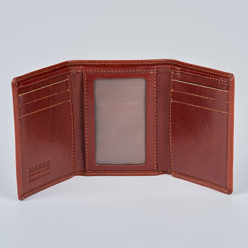The Garda Italian Trifold with ID Window by Hanks Belts is open, showing multiple card slots, a center transparent ID window, and “Hanks” embossed on the bottom left—a genuine example of Tuscan craftsmanship.