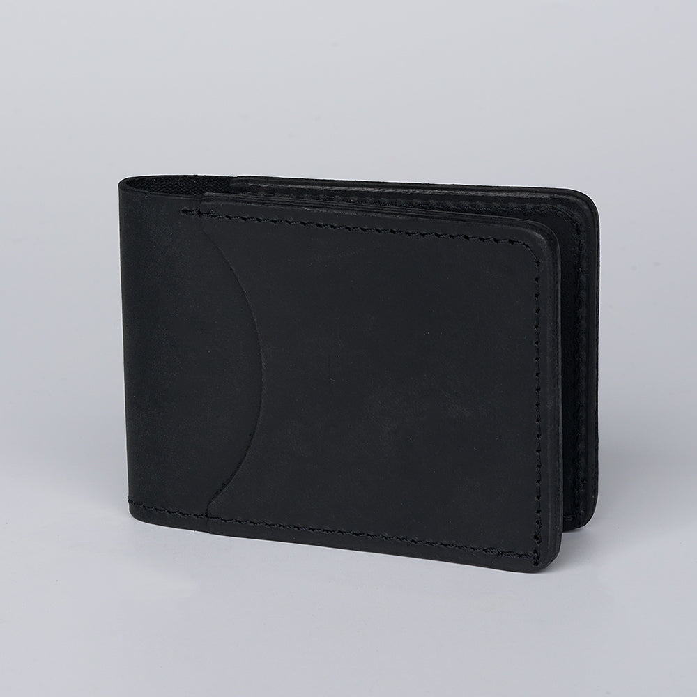 The Hanks Belts George Slimline Card Holder is a black minimalist wallet made from North American Steerhide with visible stitching, shown upright on a light gray background.