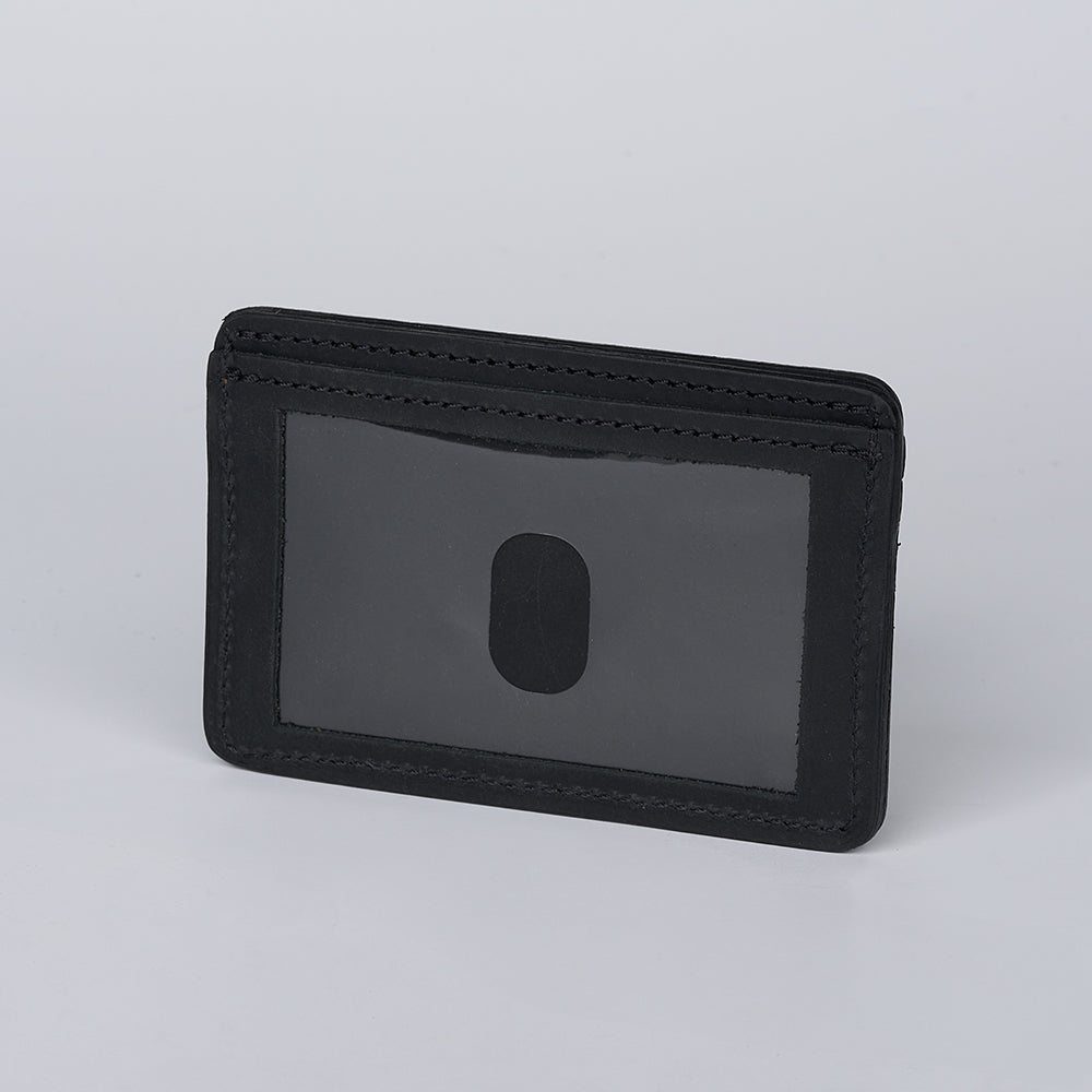 The Hanks Belts Hamlin Card Holder with ID Window, crafted from black steerhide leather and featuring a transparent ID window plus thumb slot, stands upright against a plain light gray background.