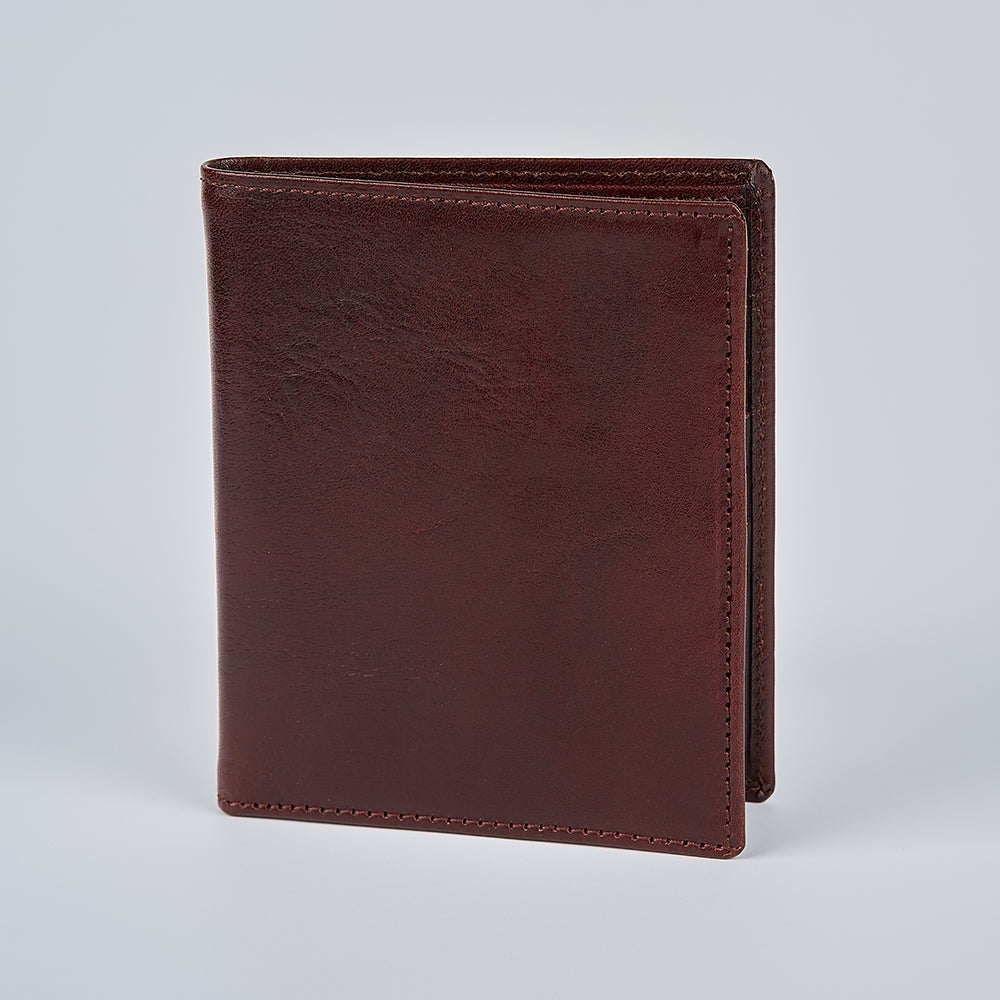 The Hanks Belts Iseo Italian Hipster Bifold, crafted from dark brown full-grain leather with visible edge stitching, stands upright and closed against a plain light gray background.
