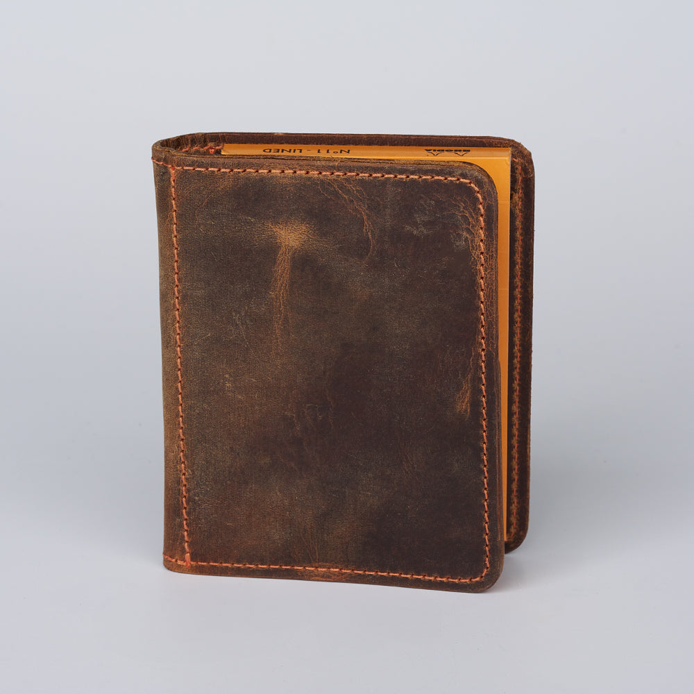 The Hanks Belts Notesman and Credit Card Wallet stands upright on a light gray surface, partially open to display its tan-colored interior.