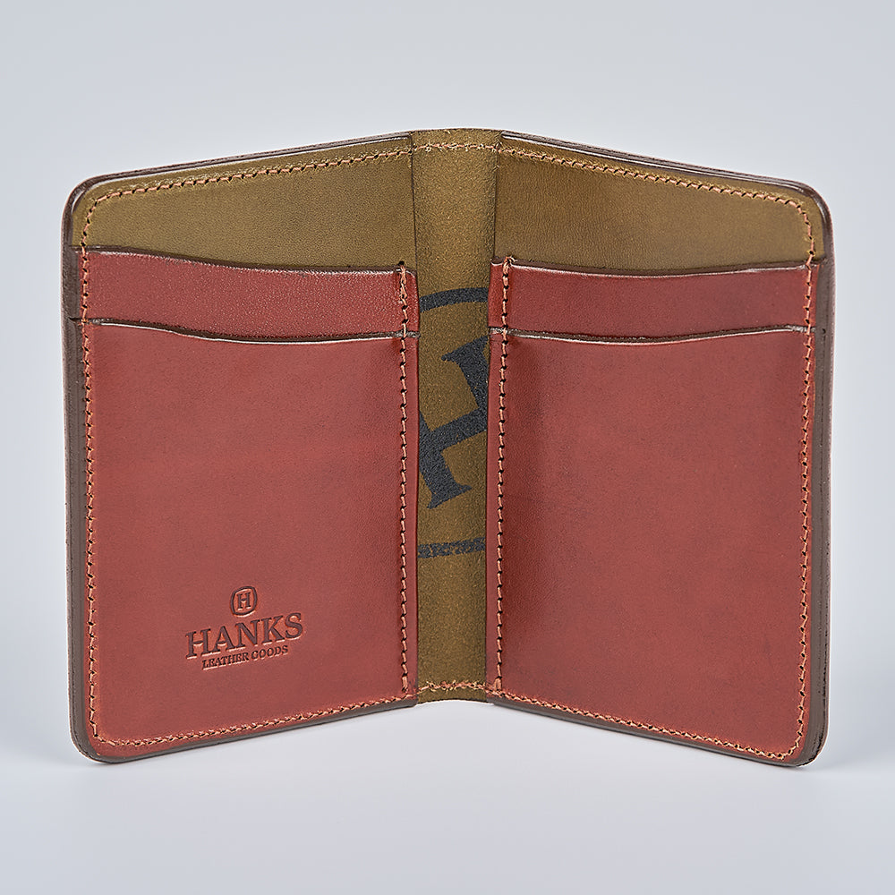 The Superior Front Pocket Bifold by Hanks Belts features open brown English Bridle Leather, four card slots, a tan interior, and "HANKS" stamped on the lower left pocket. This handcrafted wallet is stylish and durable.