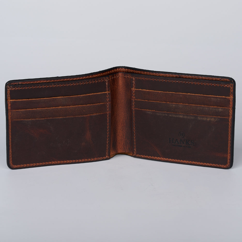 The Tahoe Bifold by Hanks Belts is an American-made brown steerhide leather wallet, featuring multiple card slots on both sides, visible edge stitching, some interior wear, and "HANKS" embossed on the right side.