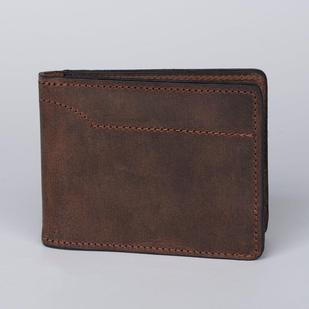 The Hanks Belts Tahoe Bifold, crafted from brown steerhide leather with visible stitching, stands upright against a plain light gray background.