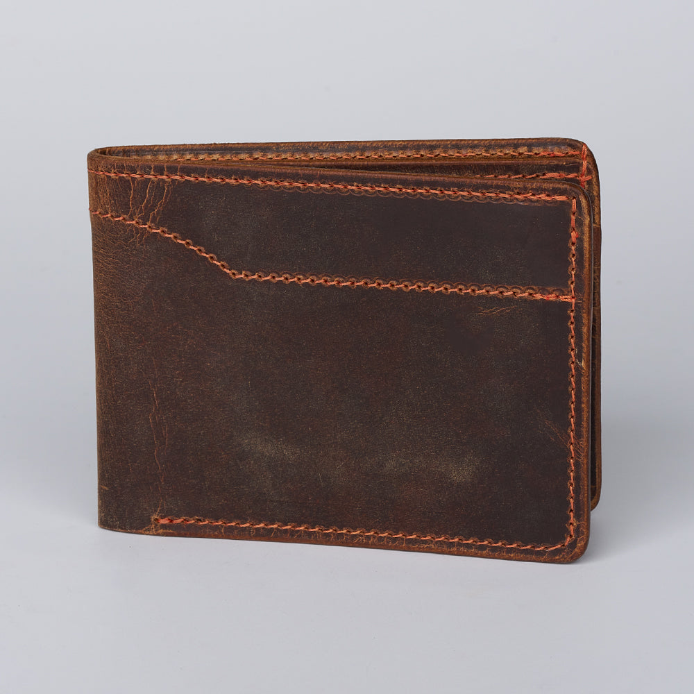 The Hanks Belts Tahoe Bifold is a dark brown steerhide leather wallet with orange stitching, shown closed and upright against a plain light background.