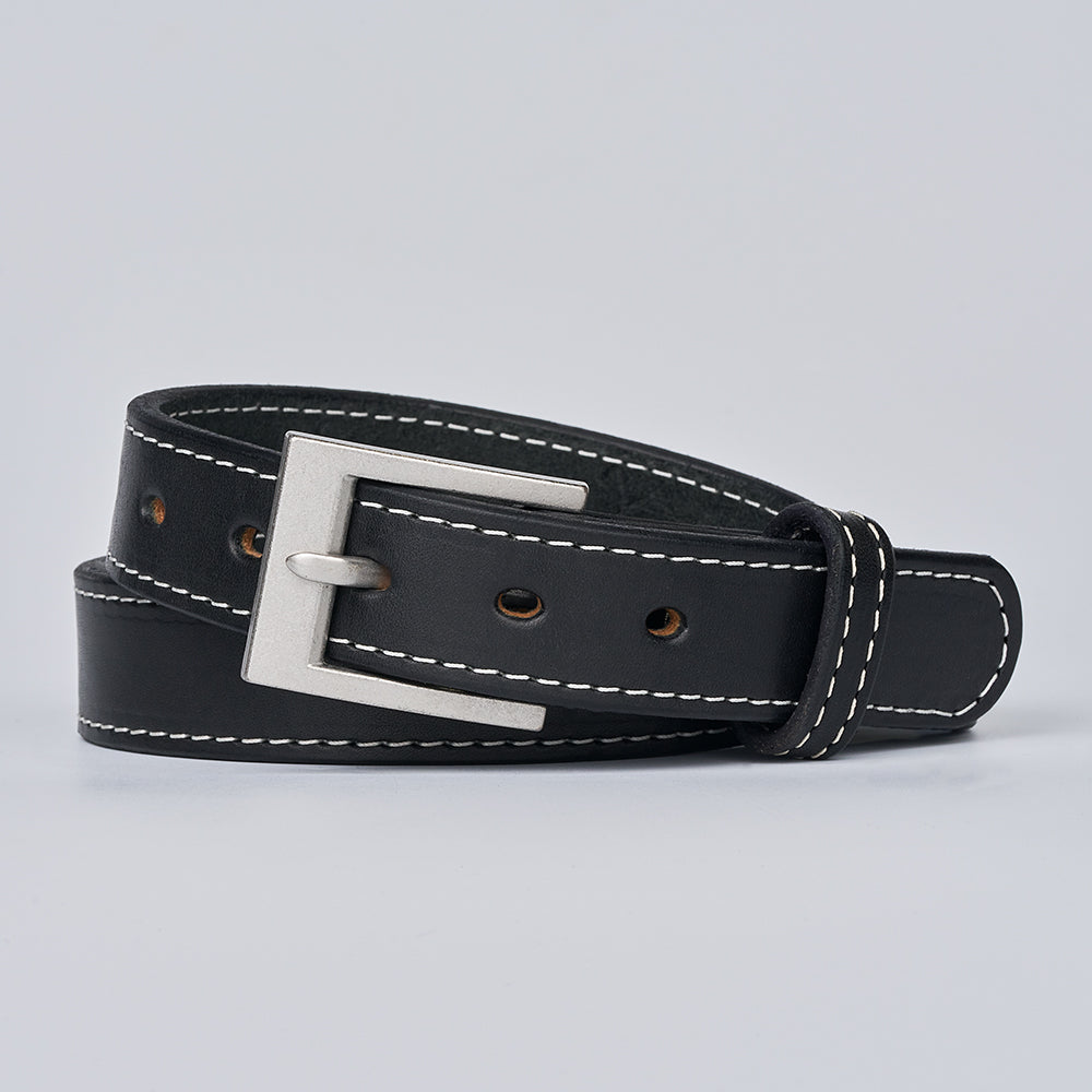 The Bonnie by Hanks Belts, a full-grain leather belt with white stitching and a silver rectangular buckle, is shown rolled up on a light gray background.