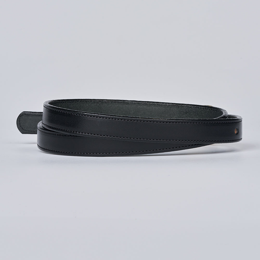 The Dixie by Hanks Belts is a black women’s leather belt made from English Bridle leather, featuring clean stitching and coiled neatly on a plain light gray background.