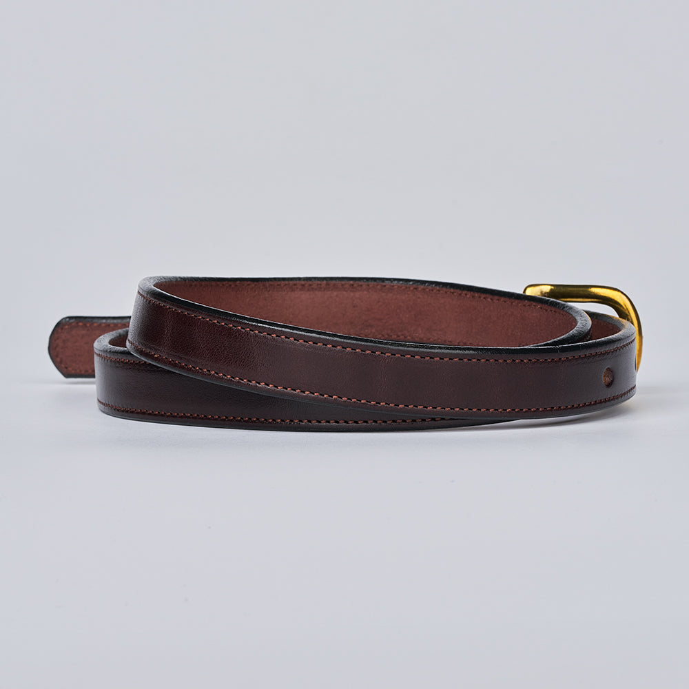 The Dixie by Hanks Belts is a coiled dark brown English Bridle leather belt with visible stitching and a gold-colored buckle, made in the USA. Displayed on a light gray background.