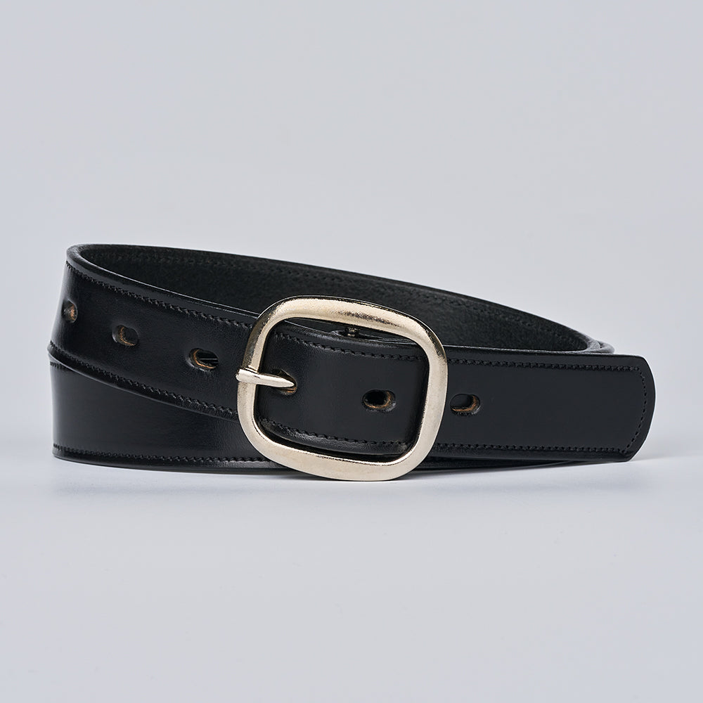 The Eloise by Hanks Belts is a black women's vegetable-tanned leather belt with multiple holes and a shiny silver rectangular buckle, made in the USA. It’s shown coiled on a plain light gray background.