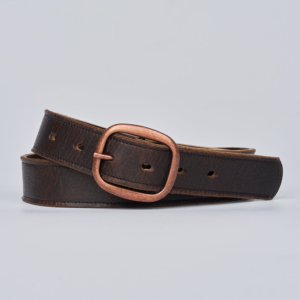 The Ember - 1.25" by Hanks Belts is a dark brown leather belt with a copper-colored rectangular buckle, displayed coiled on a plain light gray background.