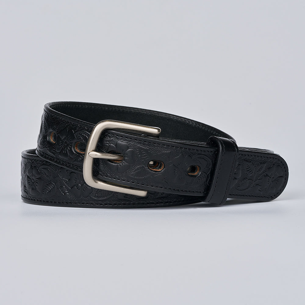 The Floral Embossed belt by Hanks Belts, crafted from black full grain leather with a silver buckle and floral embossing, is coiled neatly on a light gray background.