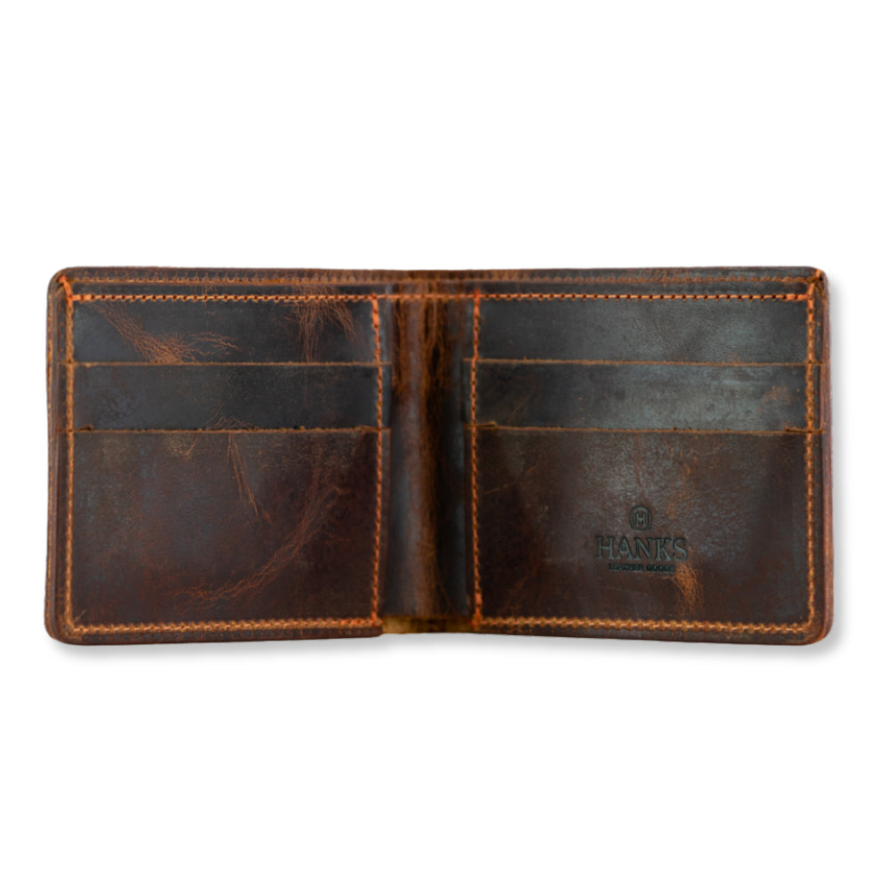 An open, worn brown Lanier Premium Bison Bifold wallet by Hanks Belts with visible stitching, card slots on both sides, and the brand name stamped inside the right panel.